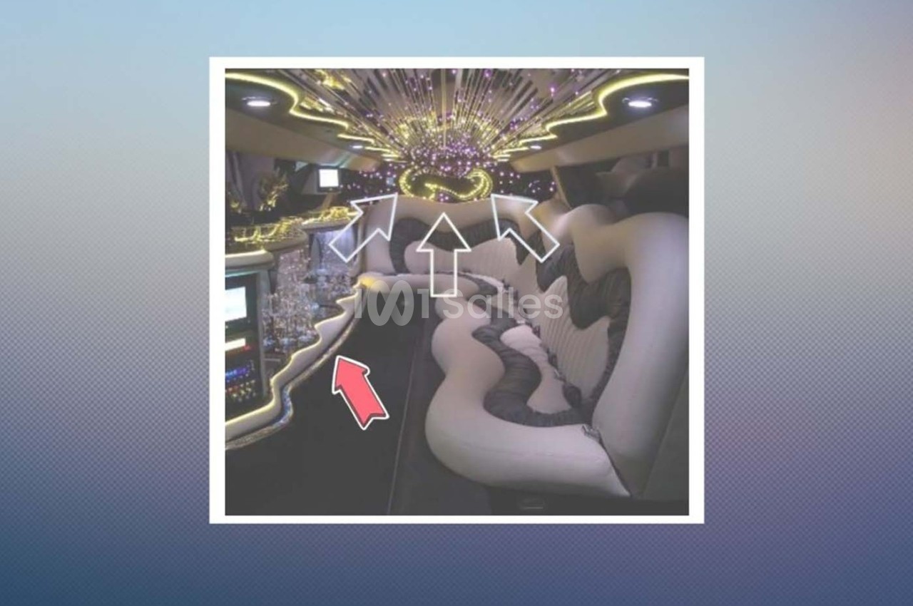 Intérieur d'une limousine avec sièges en cuir blanc, éclairage LED coloré et bar intégré.