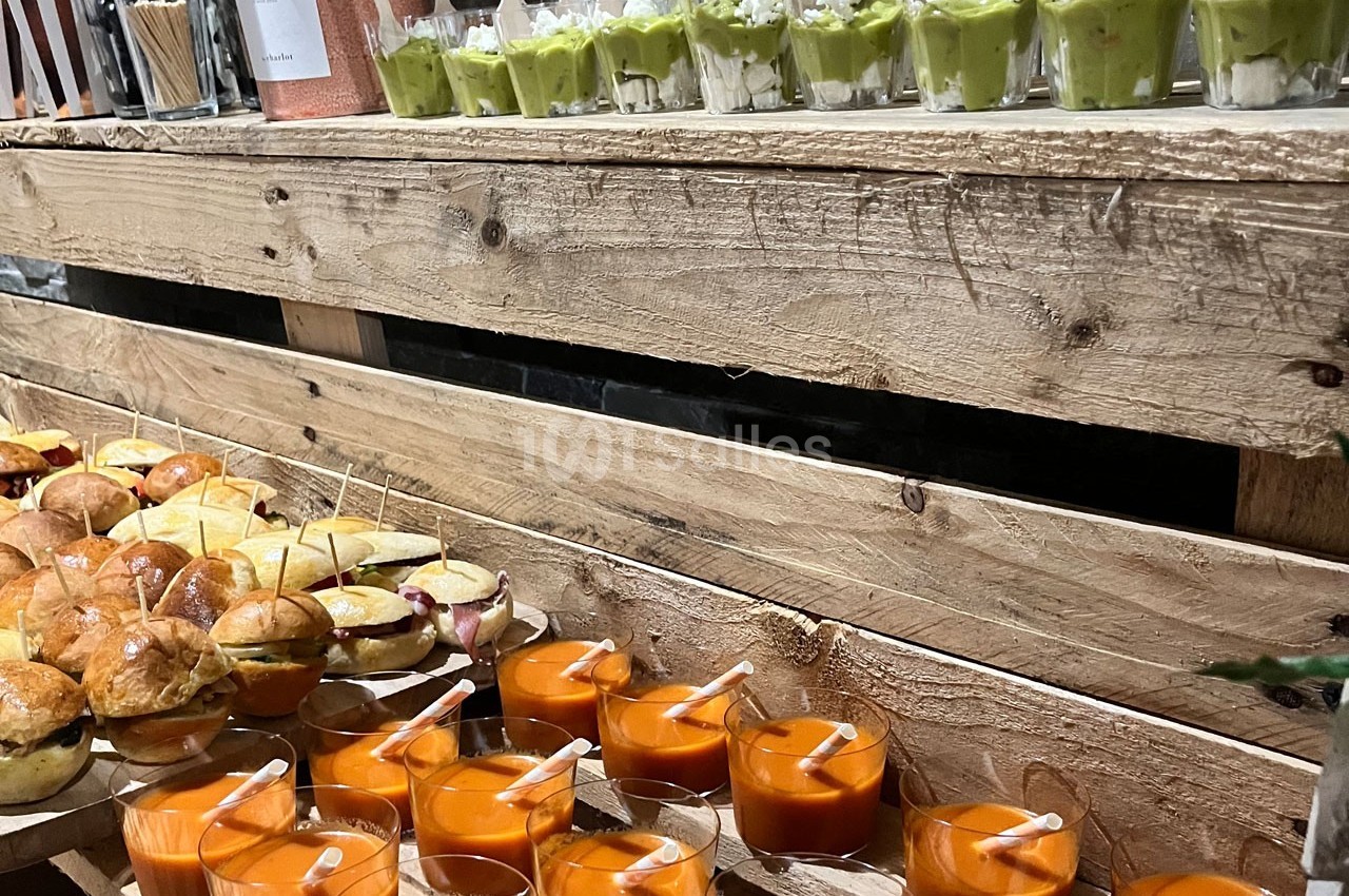 Plateau en bois avec verrines de soupe orange, guacamole et mini-sandwiches disposés pour un buffet.