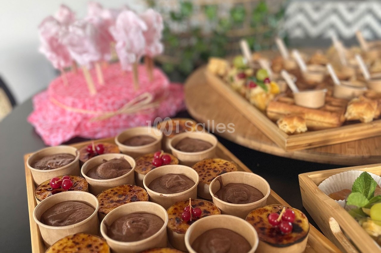 Desserts variés présentés sur une table, incluant mousses au chocolat, crèmes brûlées et brochettes de barbe à papa.
