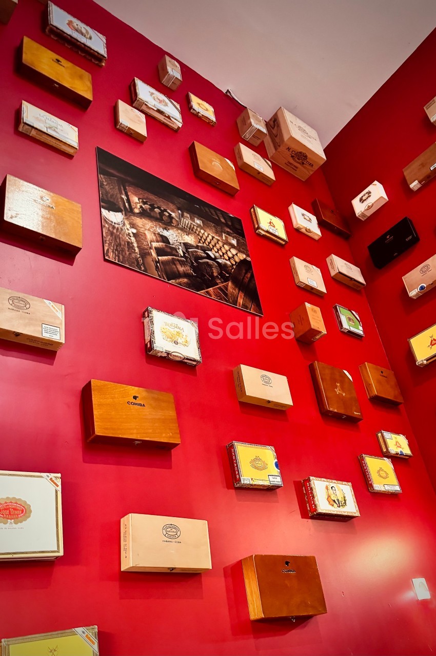 Mur rouge décoré de boîtes en bois de différentes tailles et motifs, avec un cadre photo au centre.