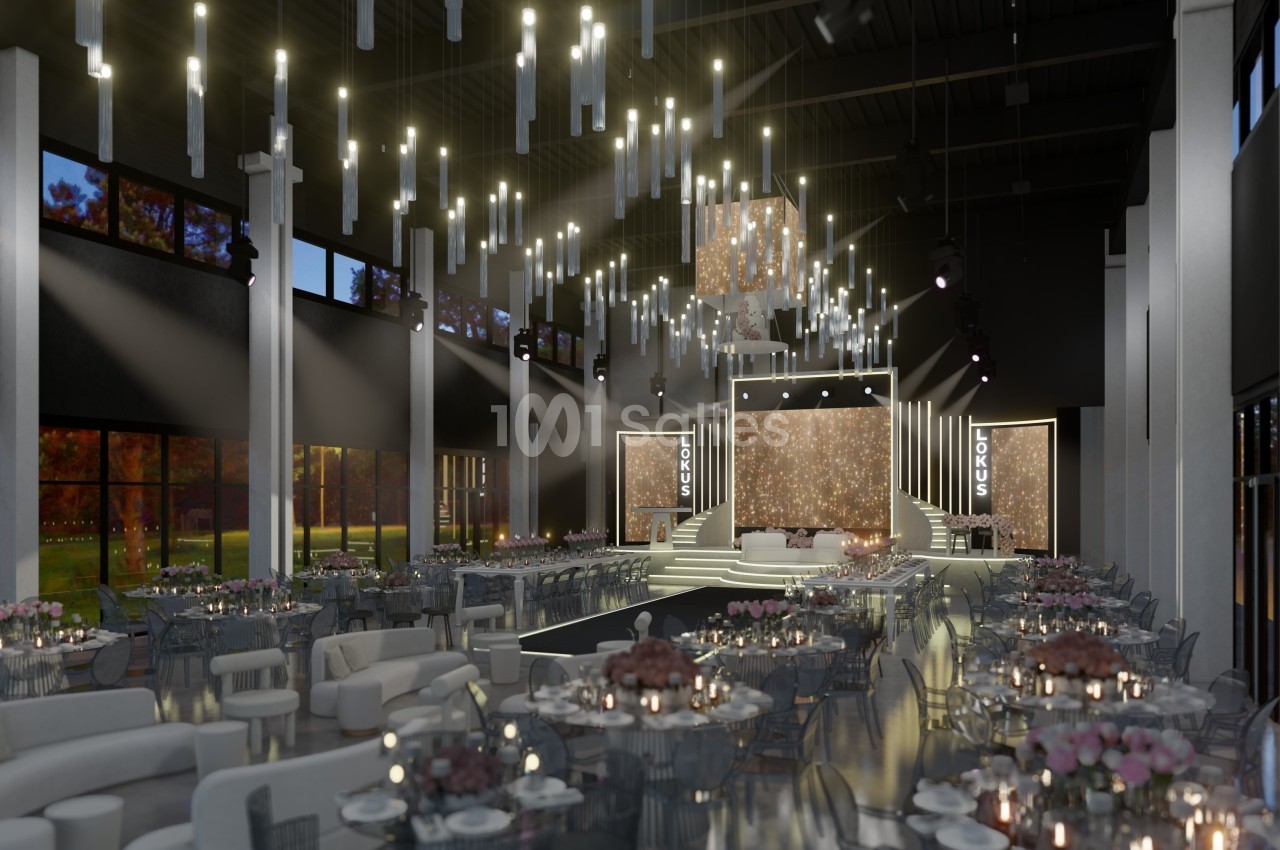 Salle de réception élégante avec tables décorées, éclairage suspendu moderne et scène centrale illuminée.