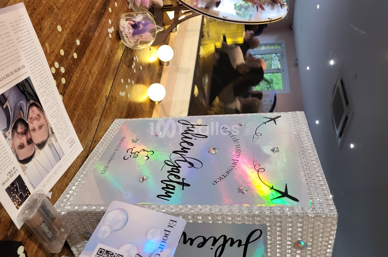 Livre d'or décoratif scintillant sur une table, entouré de confettis et d'éléments de décoration festive.