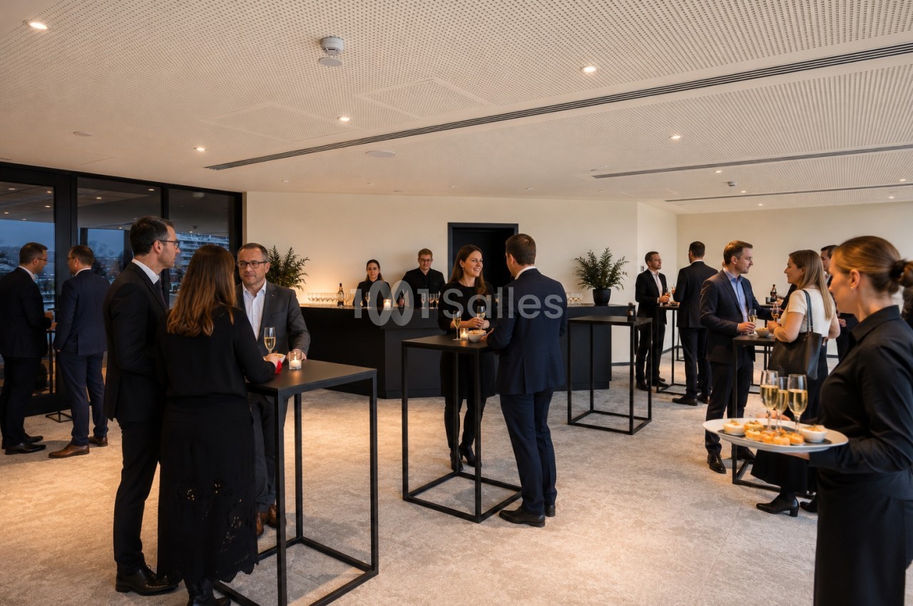 Personnes en tenue professionnelle discutant debout autour de tables hautes dans une salle lumineuse avec un service de…