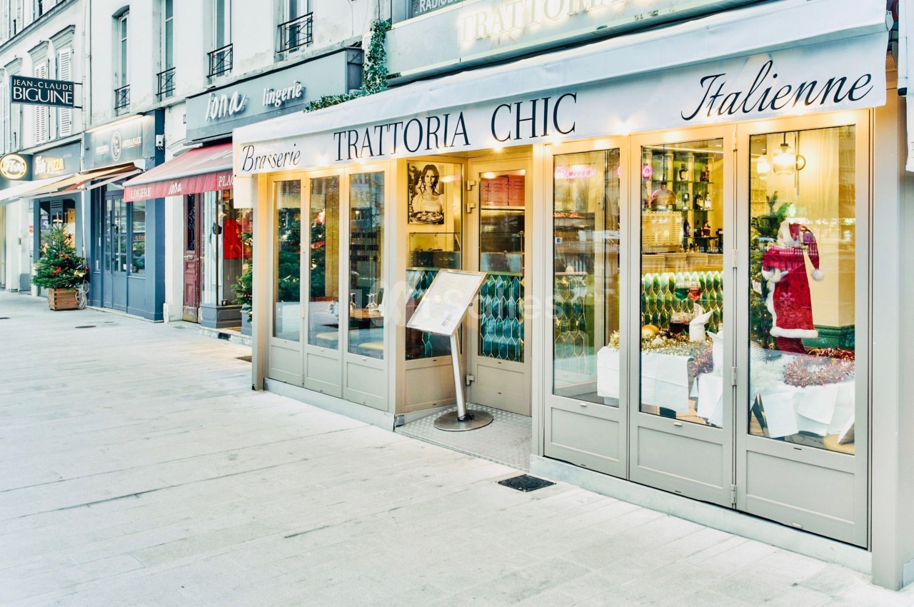 Façade d'une brasserie italienne avec une devanture vitrée et une terrasse dans une rue commerçante.