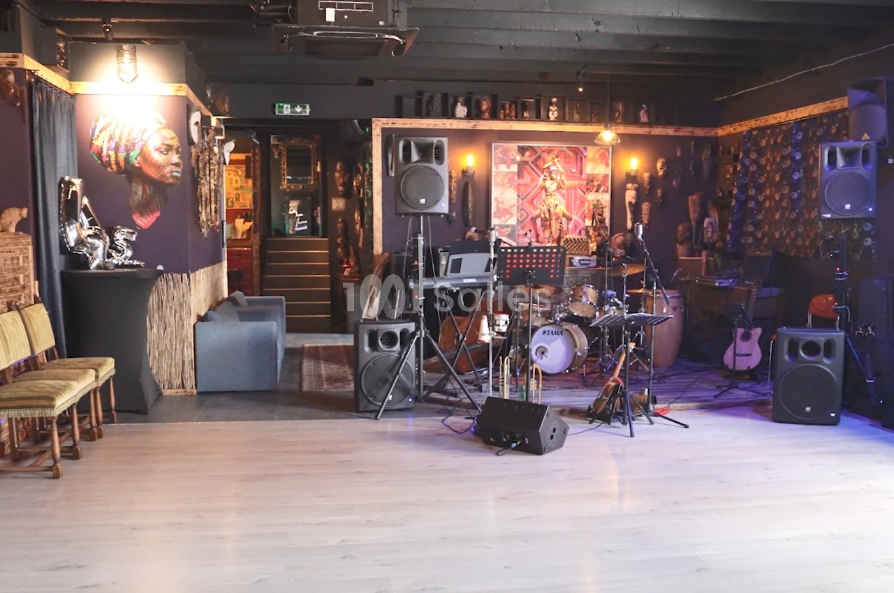 Salle de concert avec instruments de musique installés sur une scène, décorée d'œuvres d'art et éclairée par des lumières…