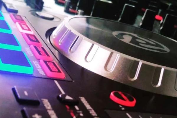 Table de mixage avec des boutons lumineux colorés et un plateau de contrôle argenté en gros plan.