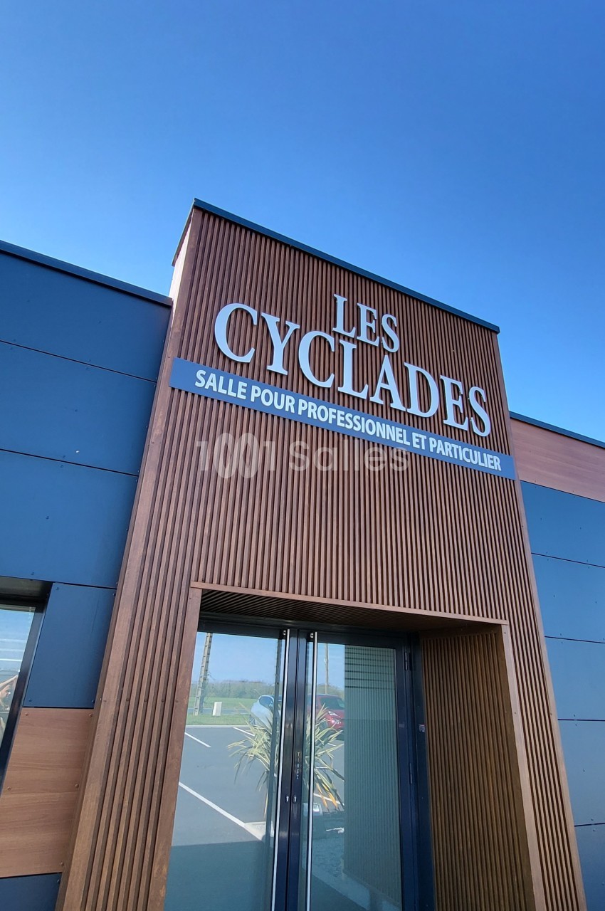 Façade d'un bâtiment moderne avec une enseigne indiquant ’Les Cyclades, salle pour professionnels et particuliers’.