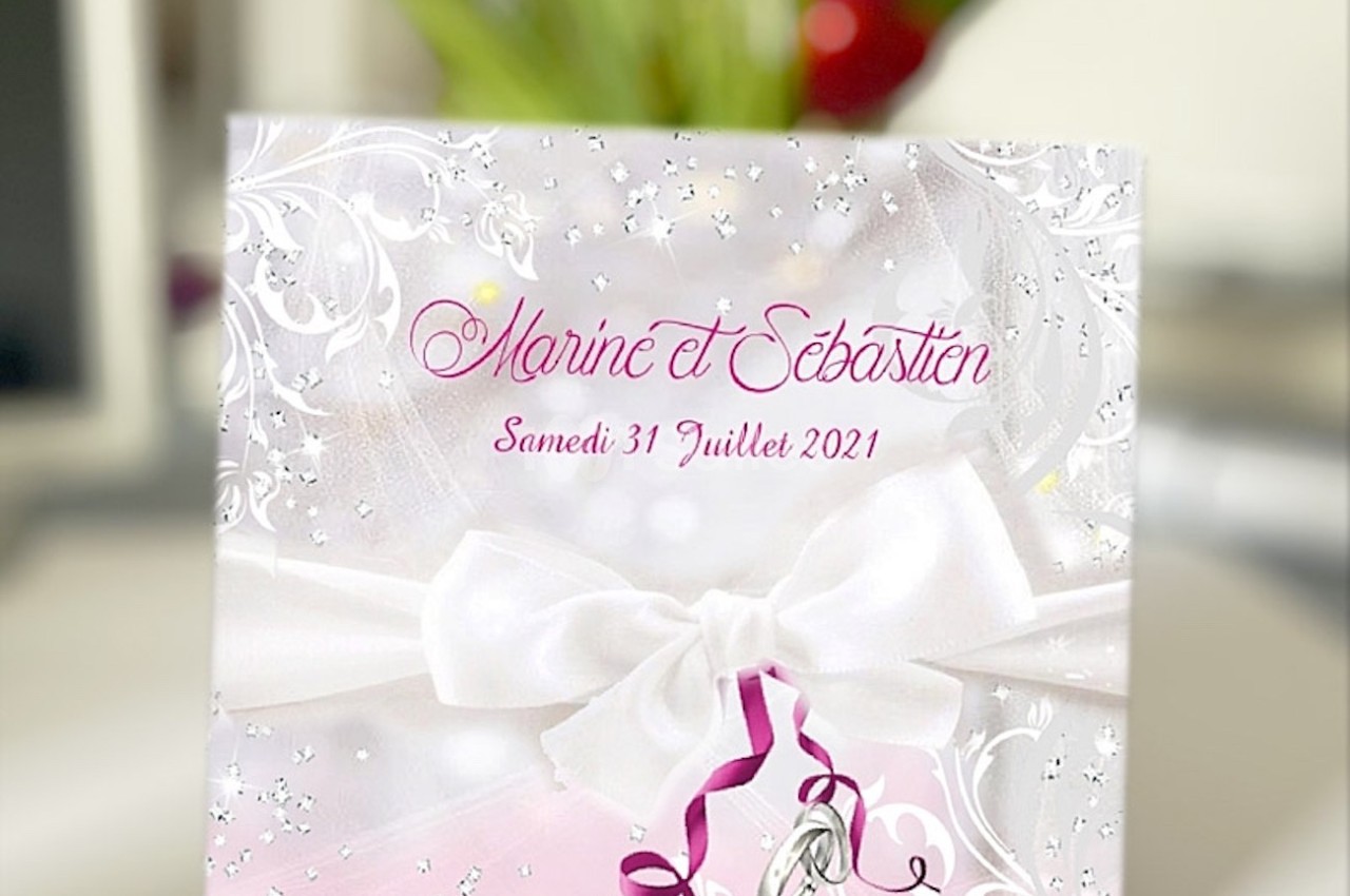 Carte d'invitation de mariage décorée de motifs argentés, ruban blanc et texte rose avec des alliances en illustration.
