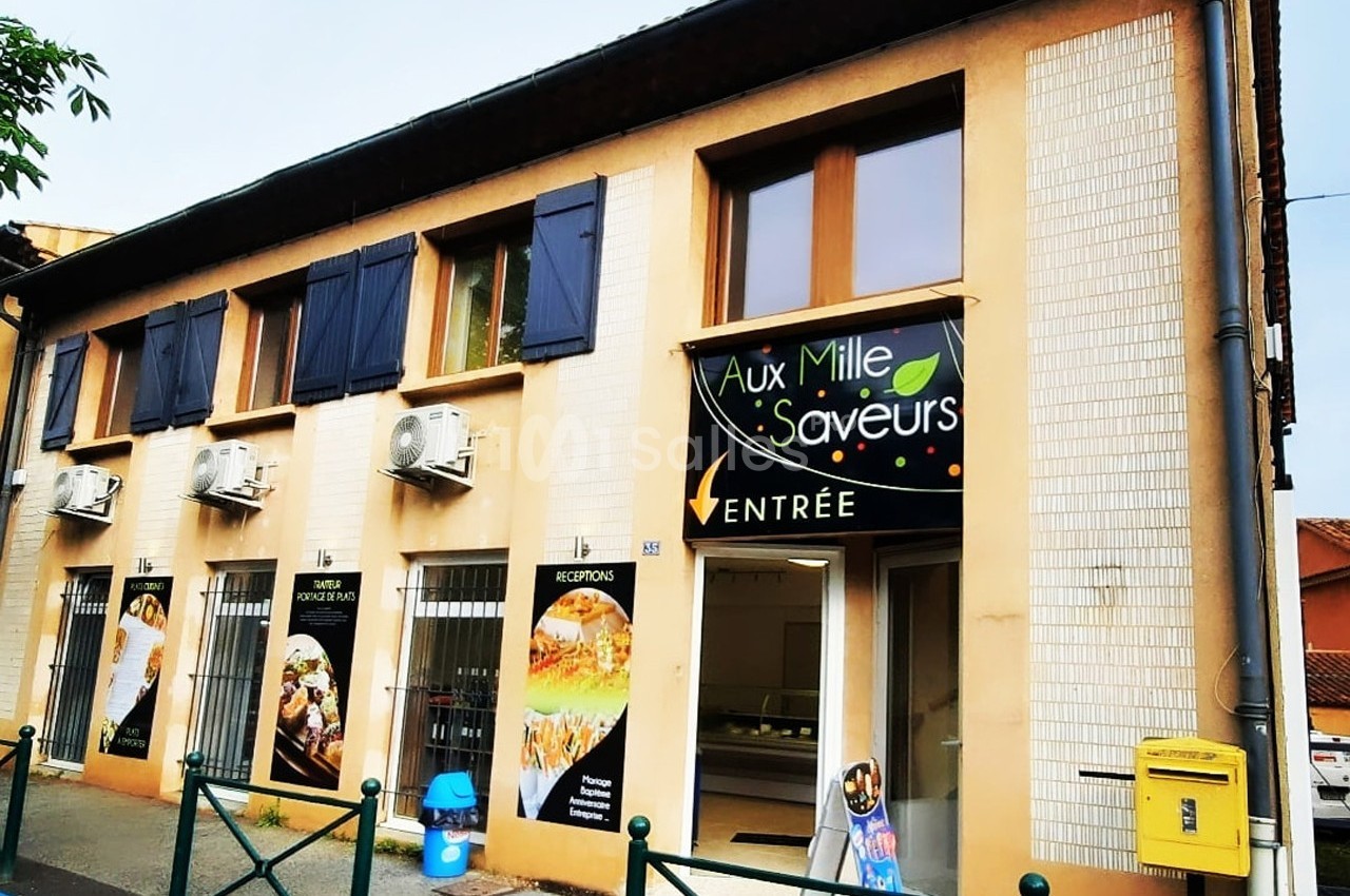 Façade d'un restaurant avec enseigne ’Aux Mille Saveurs’, entrée principale et fenêtres à volets bleus.
