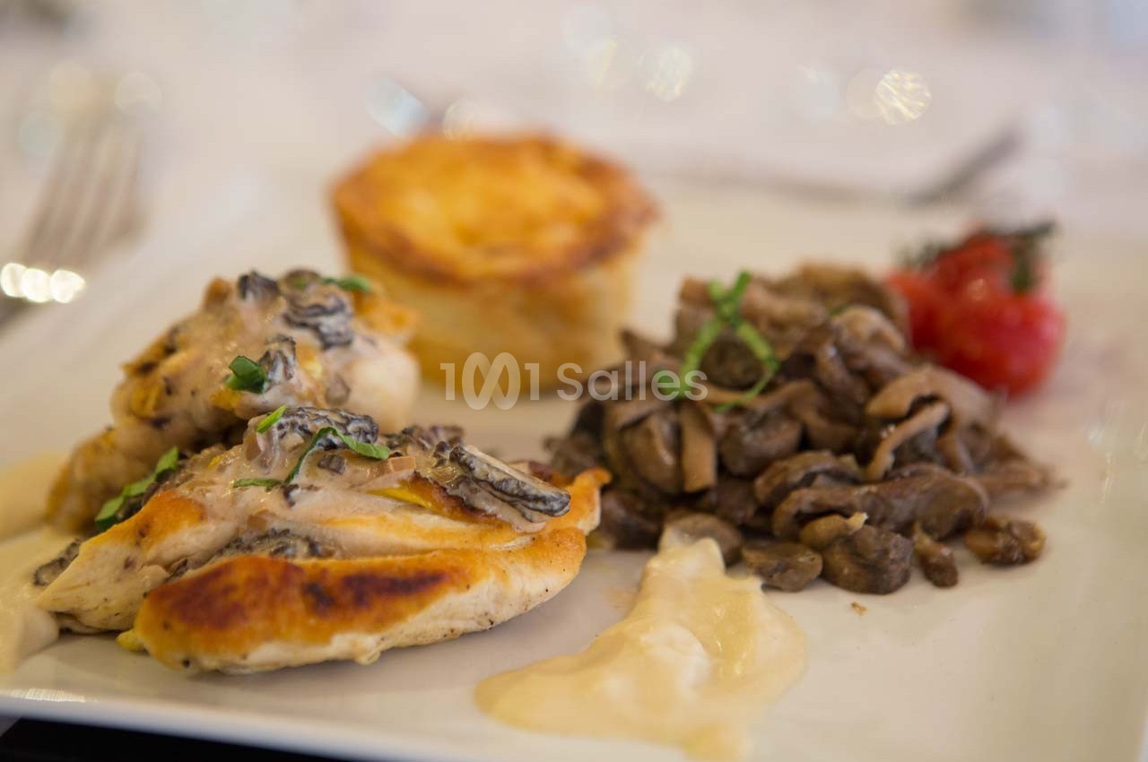 Assiette avec filet de volaille aux morilles, garniture de champignons sautés, gratin et tomate cerise.