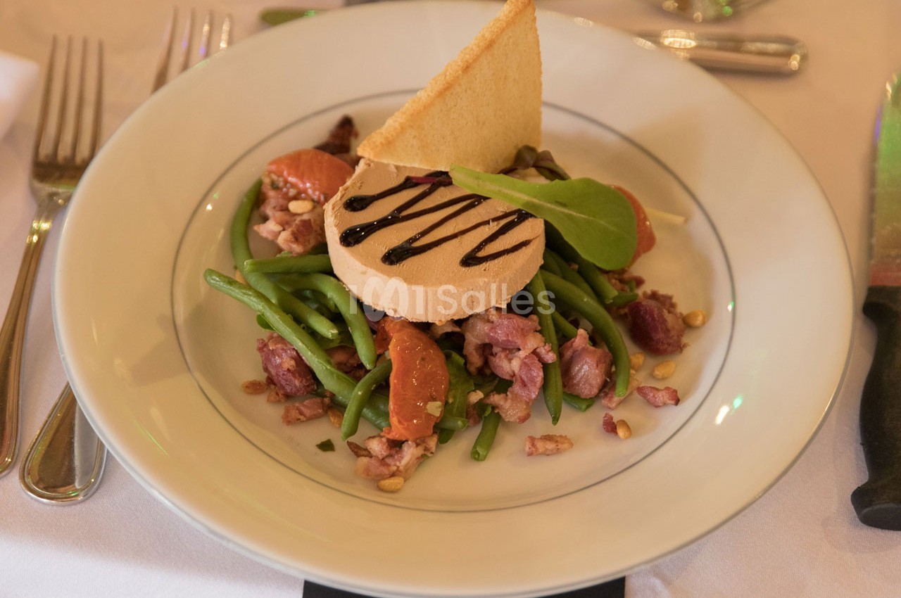 Assiette de foie gras avec haricots verts, segments d'agrumes, lardons, pignons de pin et sauce balsamique.
