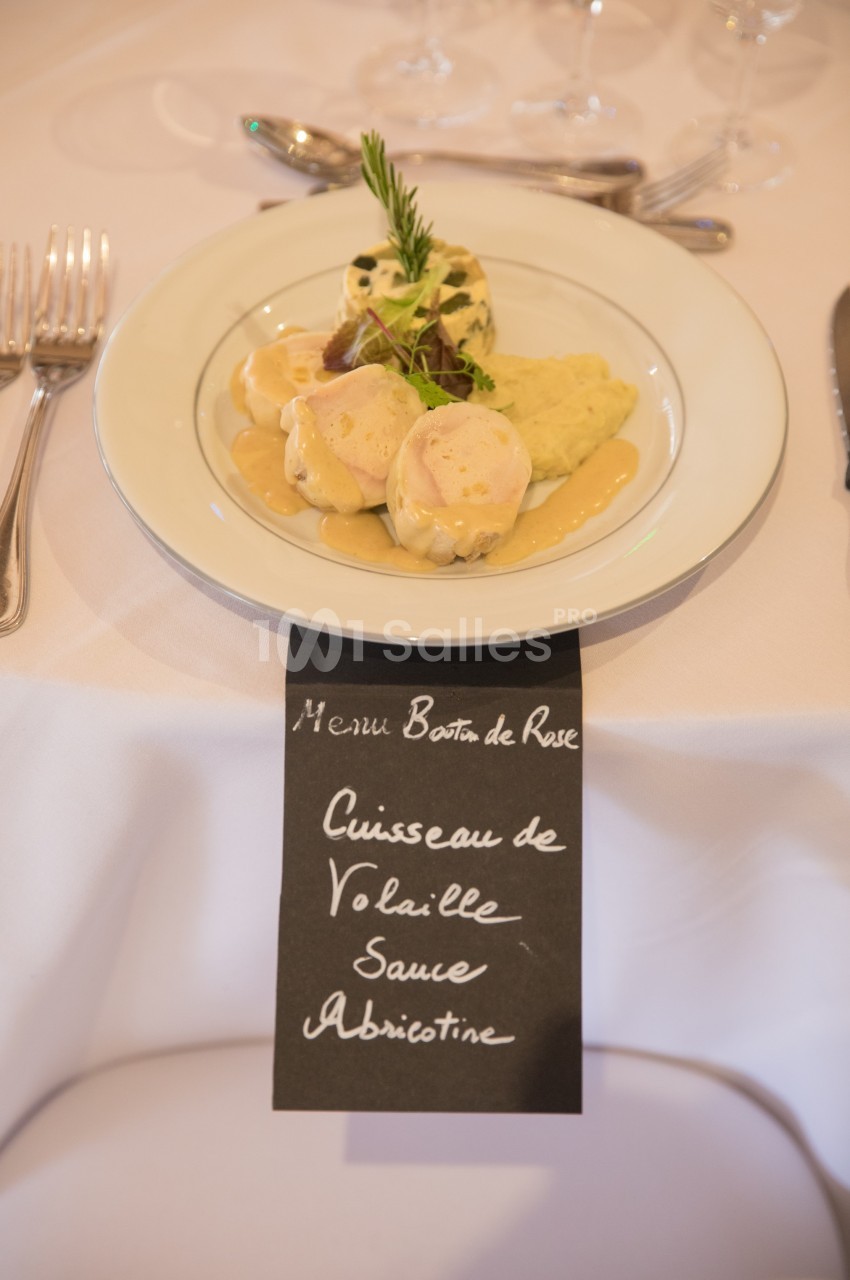 Assiette de cuisses de volaille avec sauce à l'abricotine, accompagnée de garnitures, sur une table dressée.