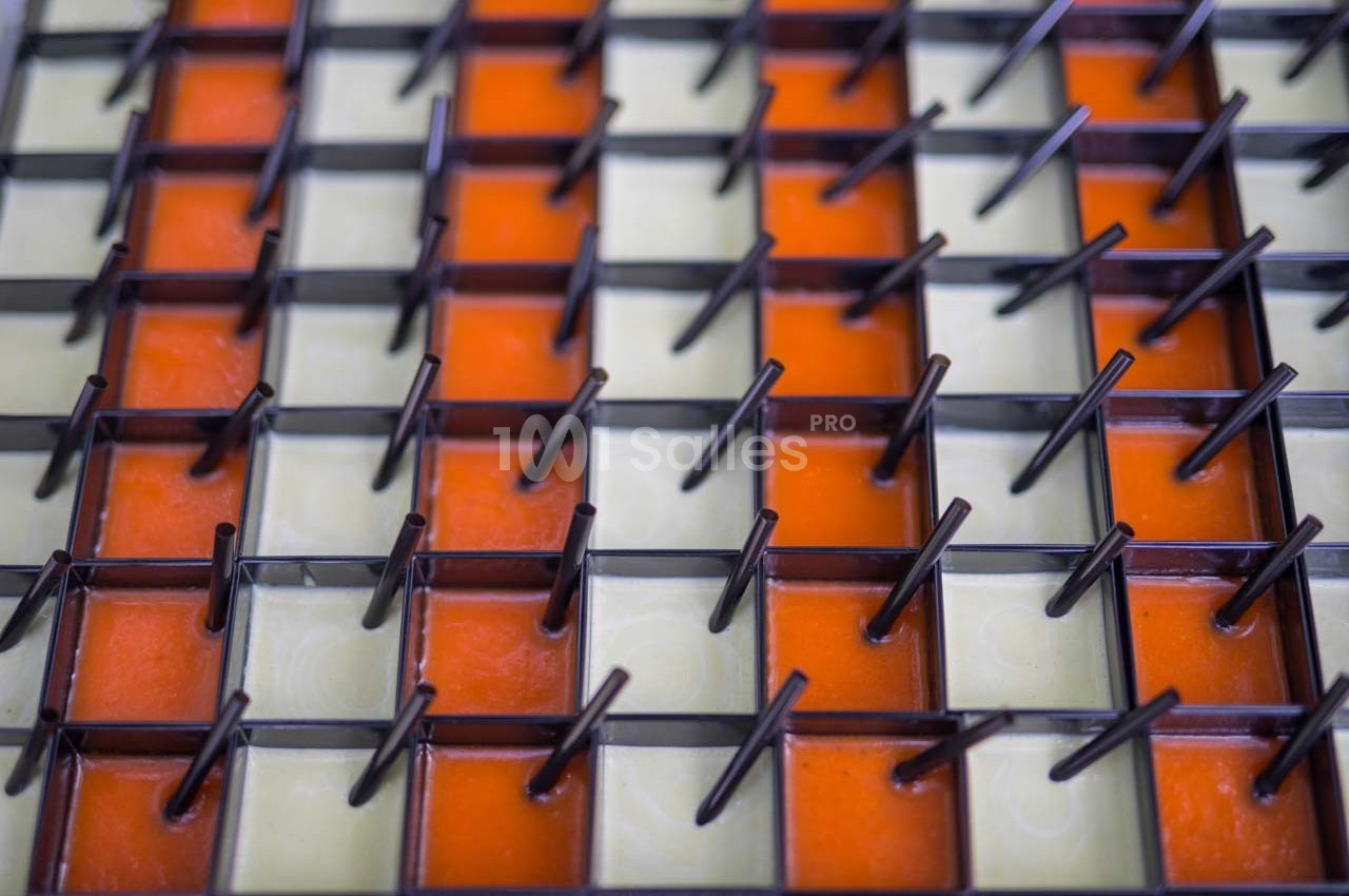 Grille métallique avec des tiges verticales, posée sur des carreaux orange et beige en alternance.