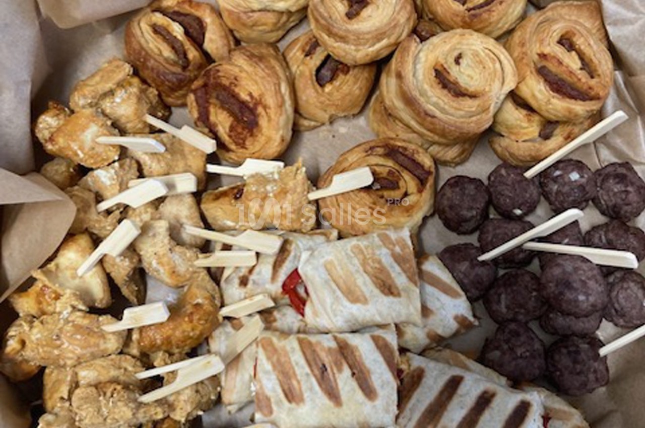 Assortiment de bouchées salées comprenant feuilletés, brochettes de poulet, roulés et boulettes de viande.