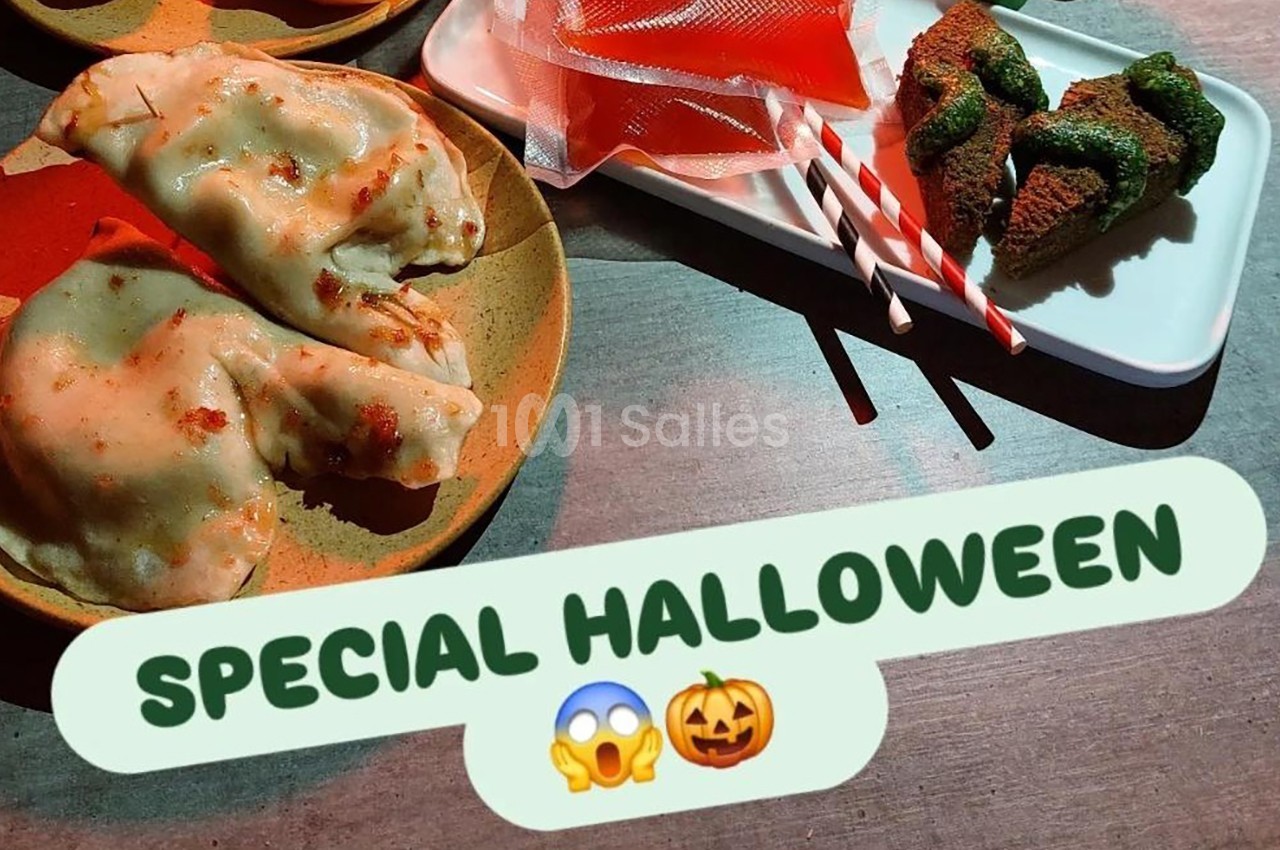 Assiette de raviolis, sucettes rouges et gâteau décoré, présentés sur une table pour une ambiance Halloween.