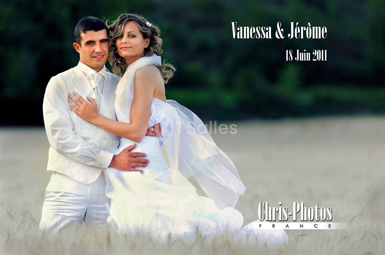 Un couple en tenue de mariage pose dans un champ avec un fond de verdure.