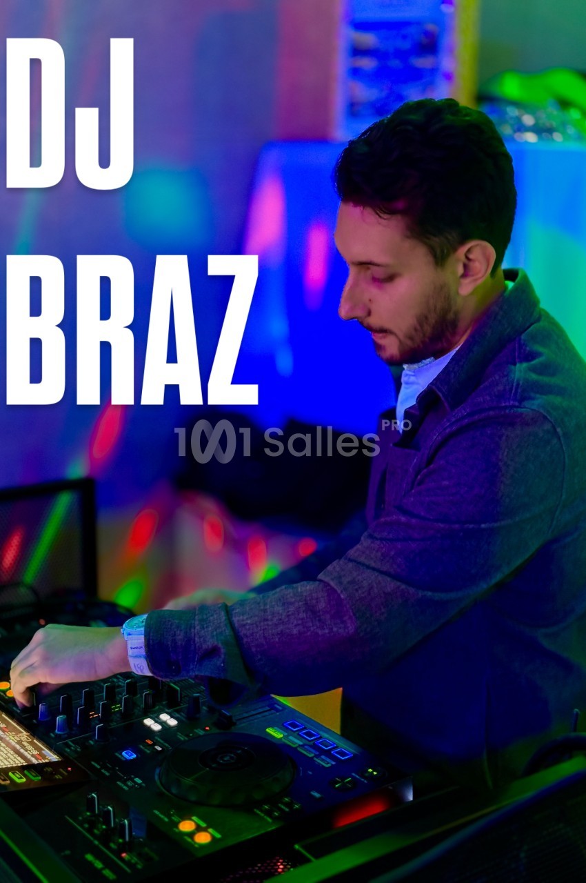 Un DJ mixant sur une table de mixage dans une ambiance lumineuse colorée.