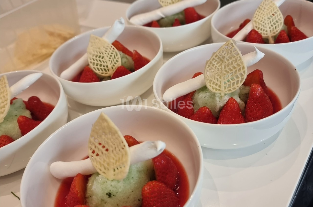 Desserts composés de fraises, sorbet vert, meringues blanches et décorations en dentelle sucrée, présentés dans des bols…