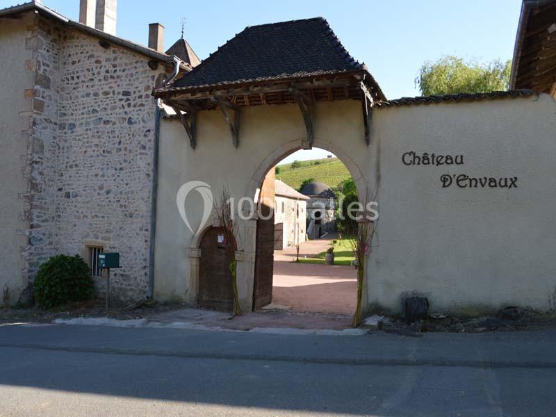 Entrée voûtée d'un château avec murs en pierre, cour intérieure visible et inscription ’Château D'Envaux’ sur le mur.