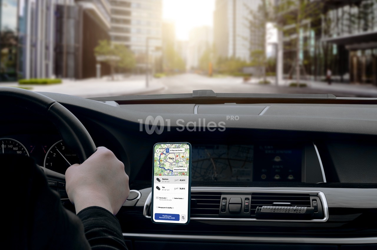 Un conducteur utilise une application GPS sur un smartphone fixé au tableau de bord d'une voiture dans une rue urbaine.