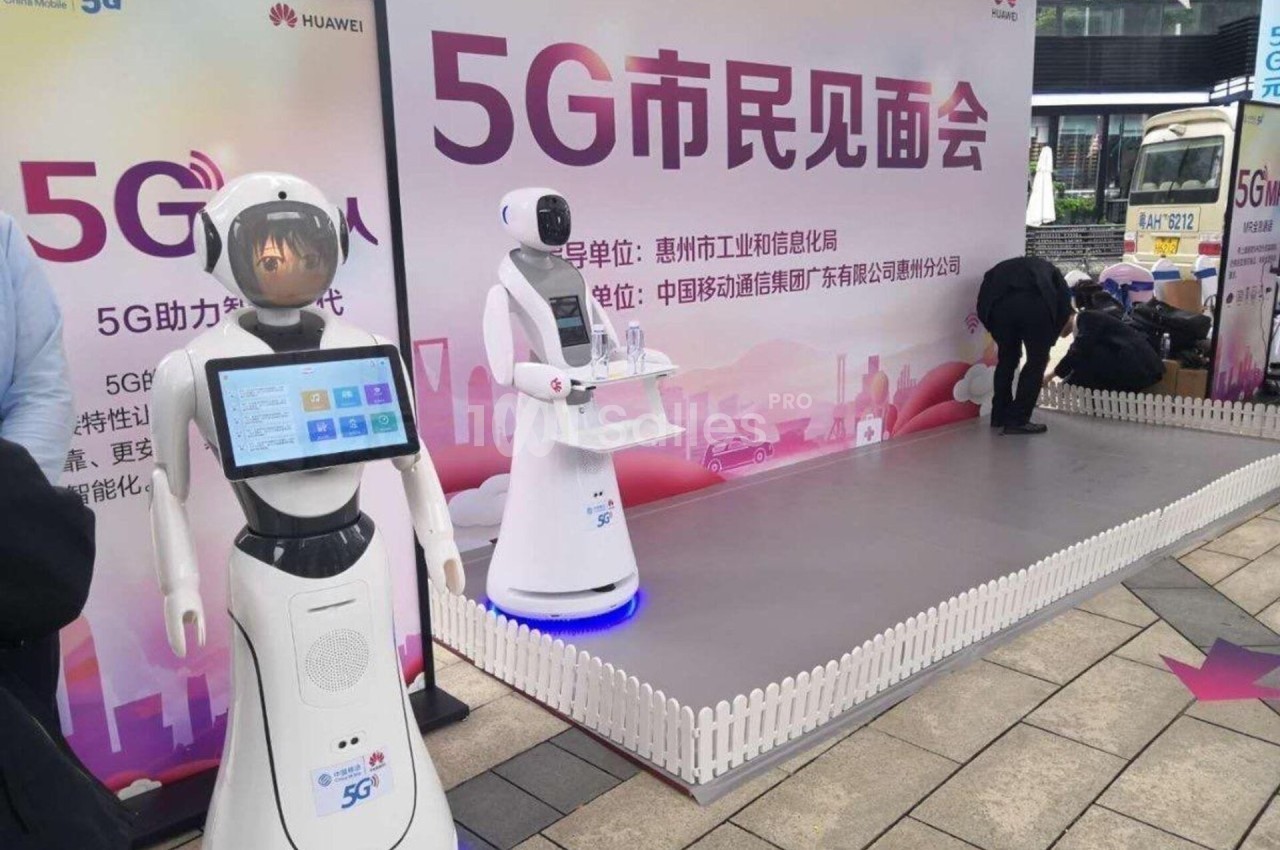 Deux robots interactifs exposés dans un stand de présentation sur la technologie 5G en extérieur.