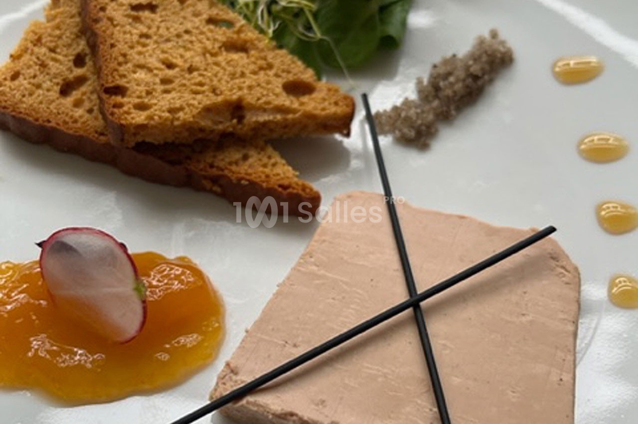 Assiette composée de foie gras, pain d'épices, confiture, radis, salade verte et décoration de sauce.