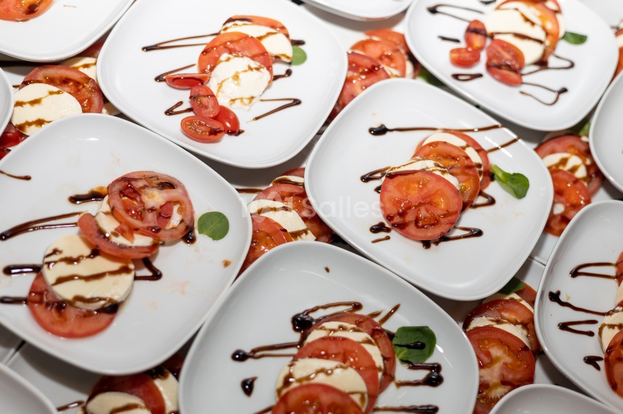 Assiettes de salade caprese avec tomates, mozzarella, basilic et filet de vinaigre balsamique.