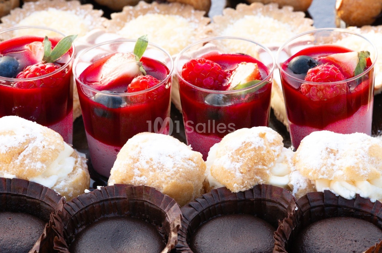Desserts variés comprenant verrines aux fruits rouges, choux à la crème et tartelettes au chocolat.