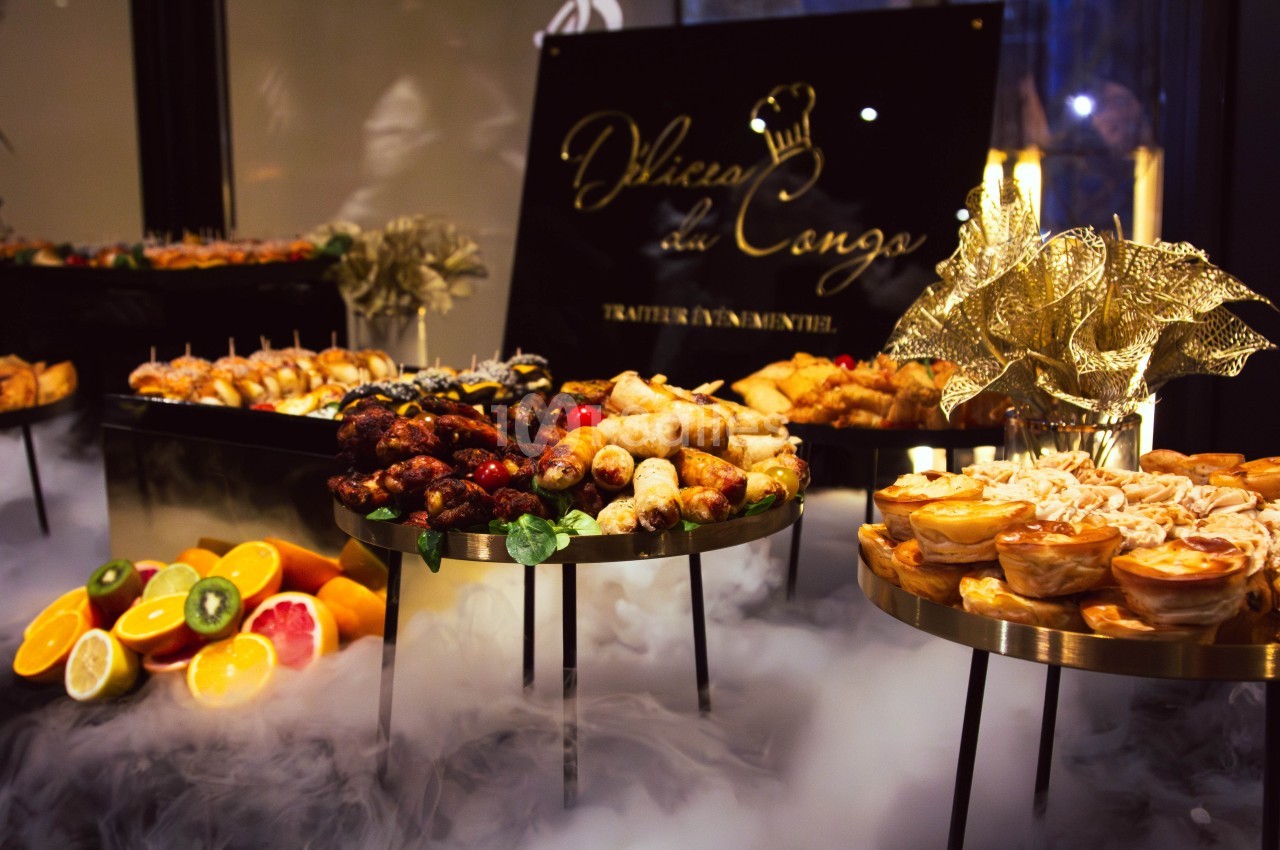 Buffet de mets variés comprenant fruits, brochettes, feuilletés et autres plats, présenté sur des plateaux élégants.