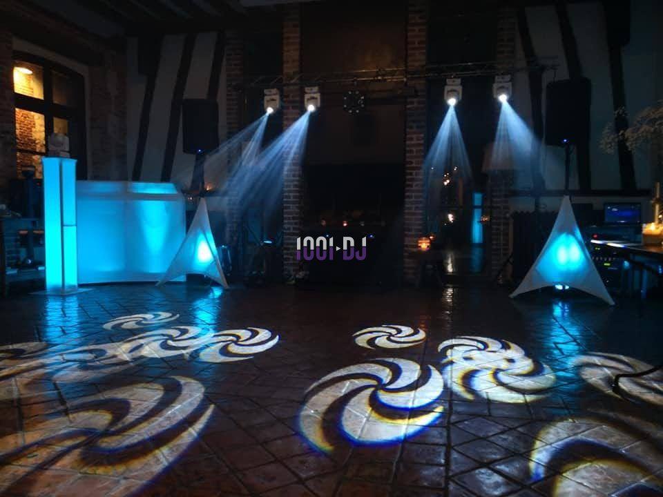 Jeu de lumières colorées projeté sur un sol carrelé dans une salle avec équipement de sonorisation et éclairage.