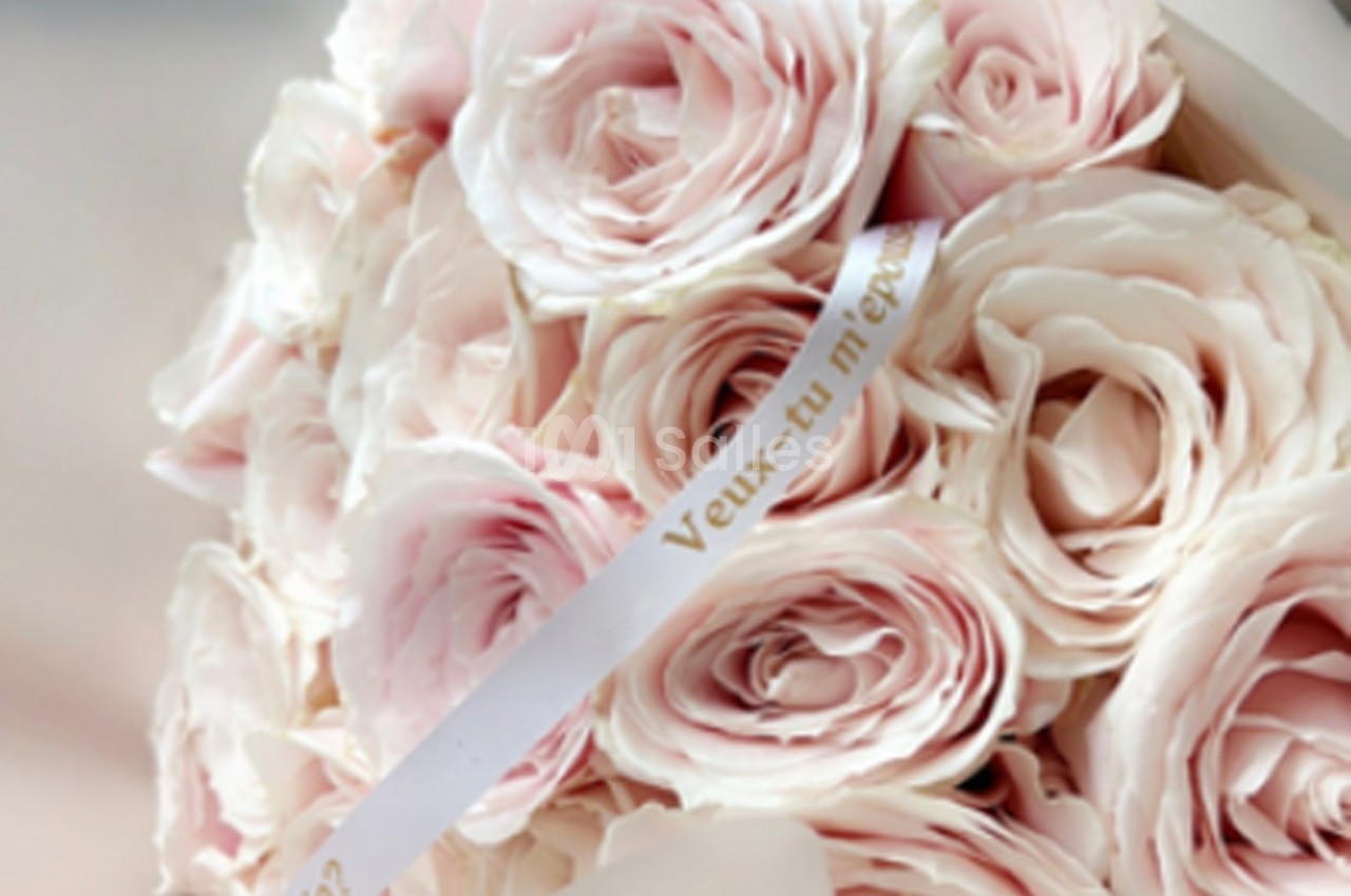 Bouquet de roses roses pâles avec un ruban portant l'inscription ’Veux-tu m'épouser ?’.
