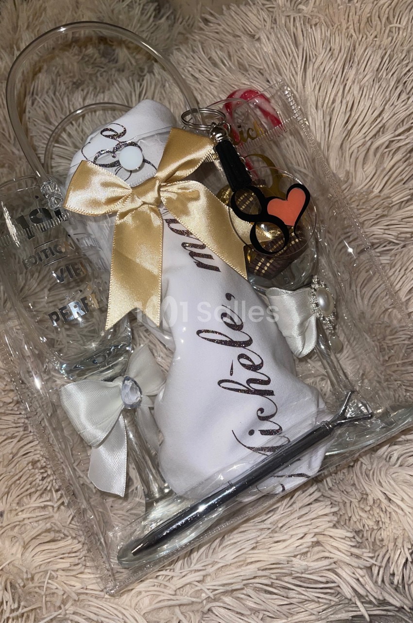 Ensemble cadeau comprenant des verres, un tissu personnalisé et des accessoires, présenté sur un fond en tissu beige.