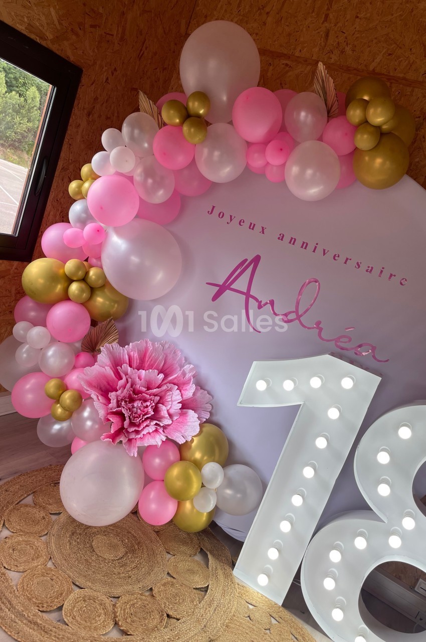 Décoration d'anniversaire avec arche de ballons roses, blancs et dorés, panneau ’Joyeux anniversaire’ et chiffre lumineux…