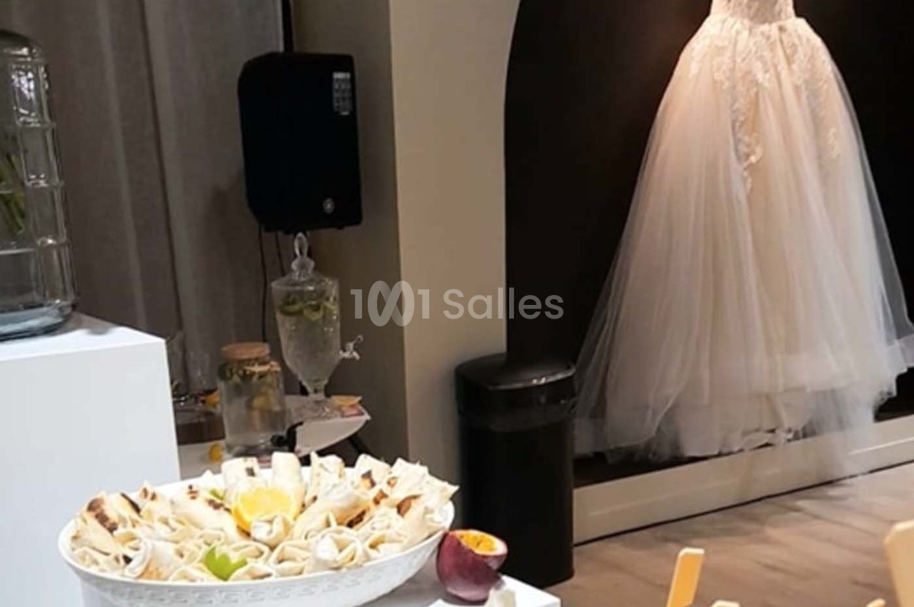 Assiette de wraps garnis posée sur une table, avec une robe de mariée exposée en arrière-plan.