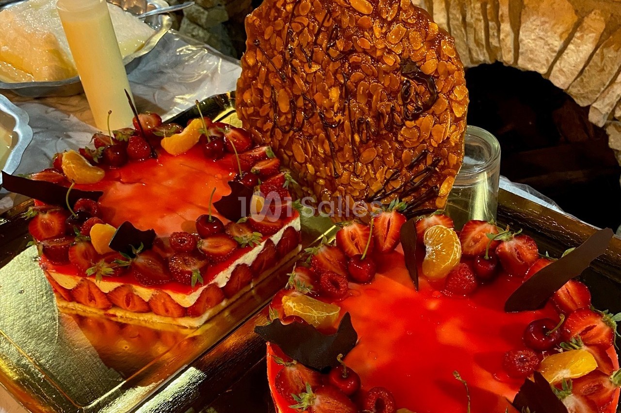 Deux gâteaux aux fraises et oranges décorés de chocolat, avec une tuile aux amandes en arrière-plan.