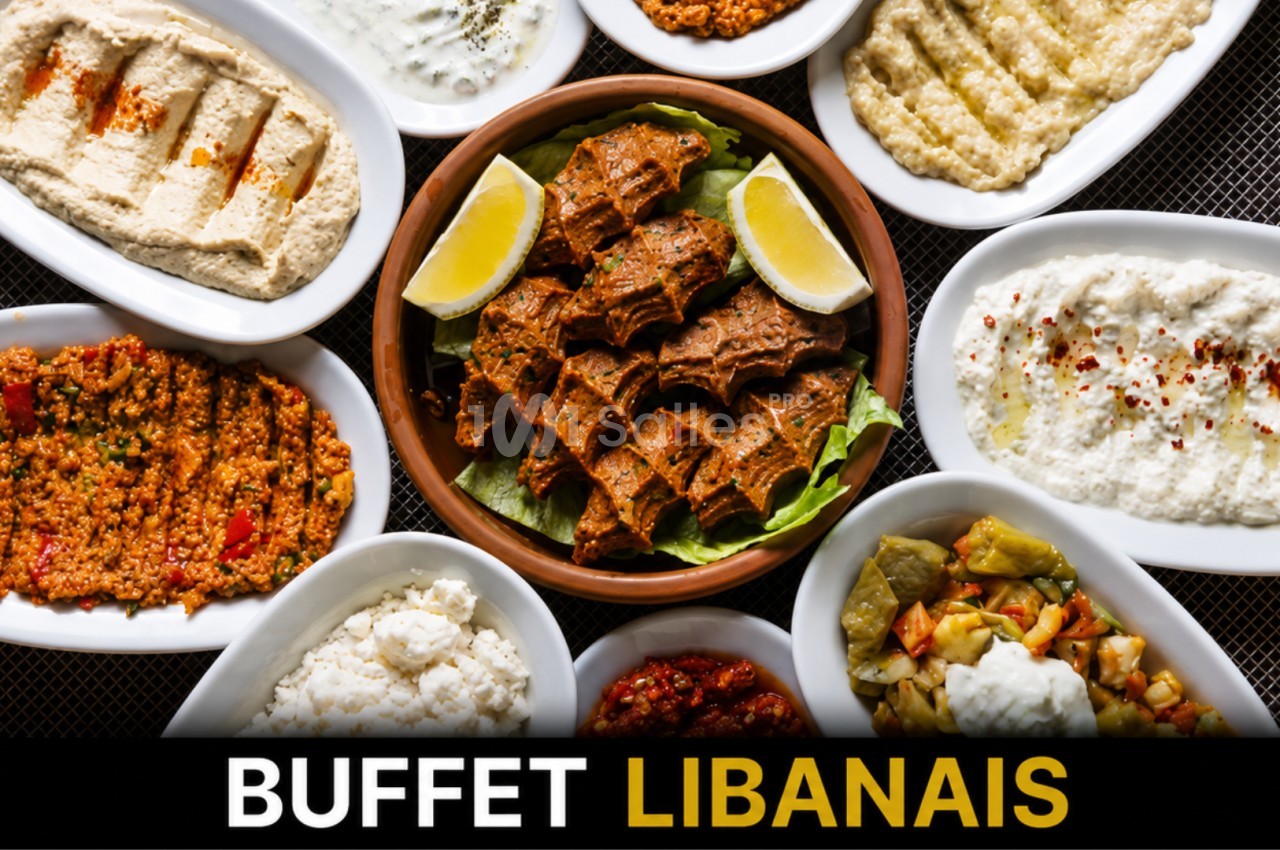 Assortiment de plats libanais variés présentés dans des assiettes blanches autour d'un plat central garni de citron.