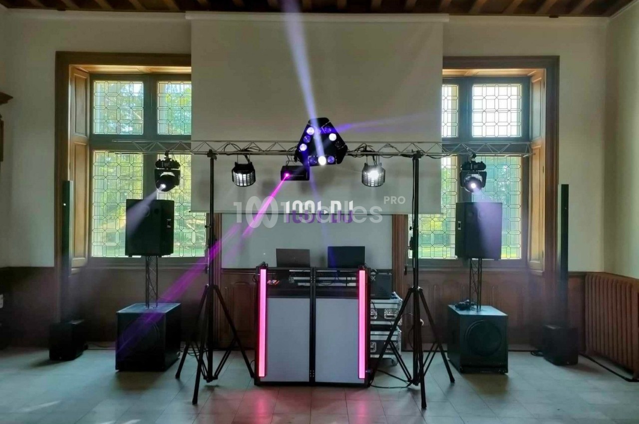 Installation de matériel de sonorisation et d'éclairage dans une salle avec projecteurs et enceintes sur pieds.