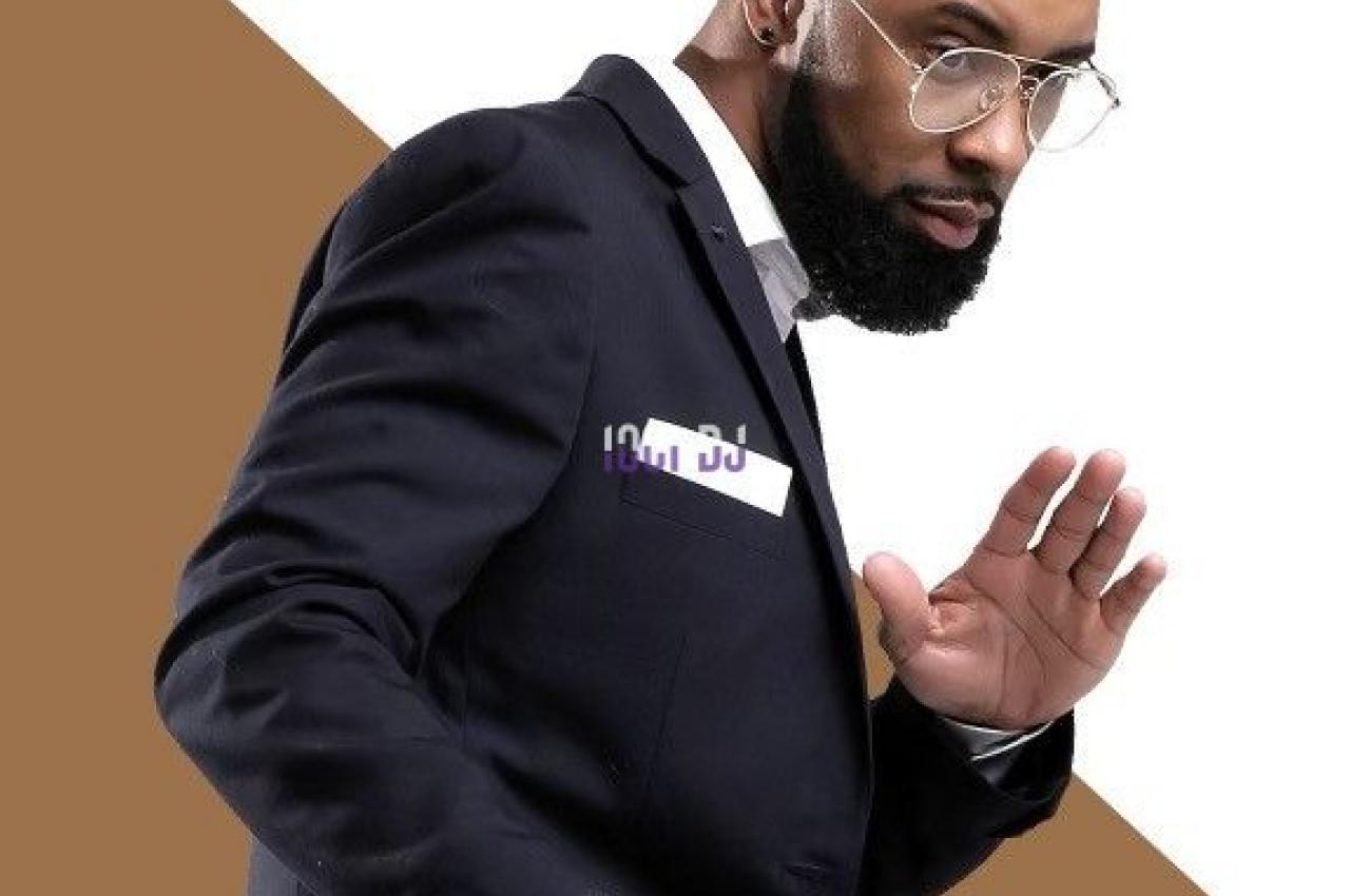 Homme barbu en costume sombre adoptant une posture dynamique, sur fond blanc et marron avec un logo ’T-WAY’.