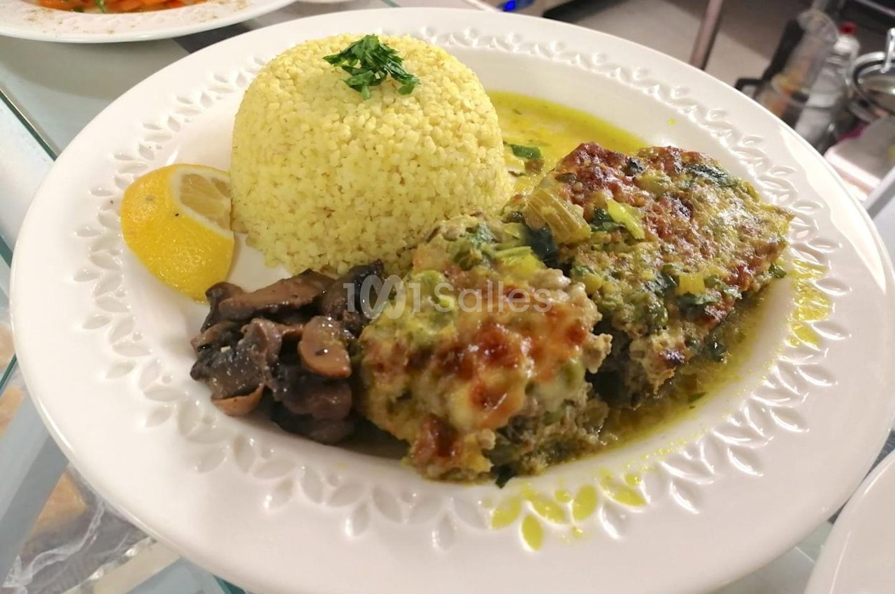 Assiette contenant un gratin de légumes, du riz, des champignons sautés et une tranche de citron.