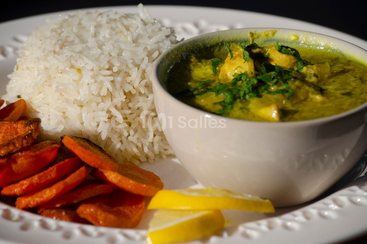 Assiette composée de riz blanc, de carottes rôties et d'un bol de curry vert garni de coriandre.