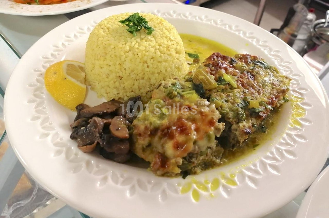 Assiette contenant un gratin de légumes, du riz, des champignons sautés et une tranche de citron.