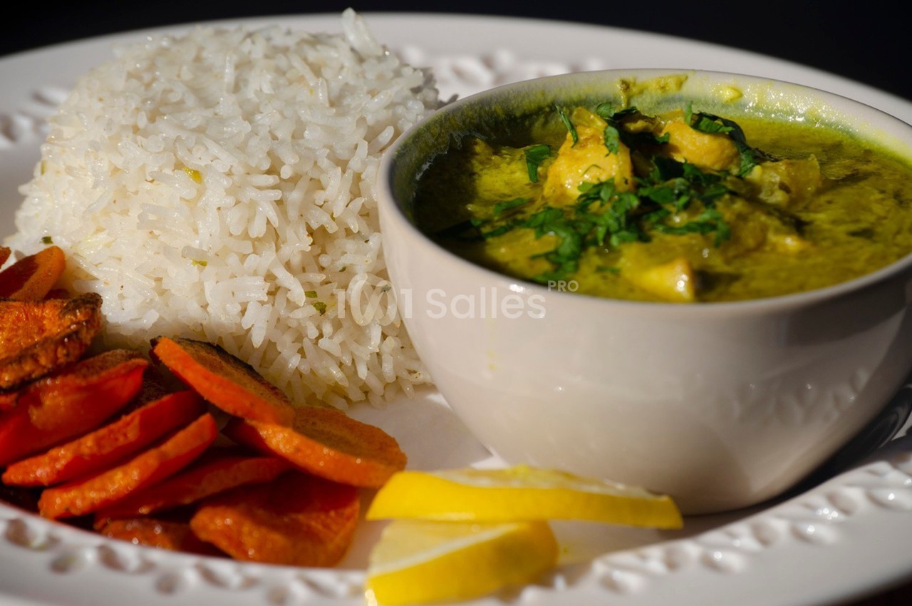 Assiette composée de riz blanc, de carottes rôties et d'un bol de curry vert garni de coriandre.