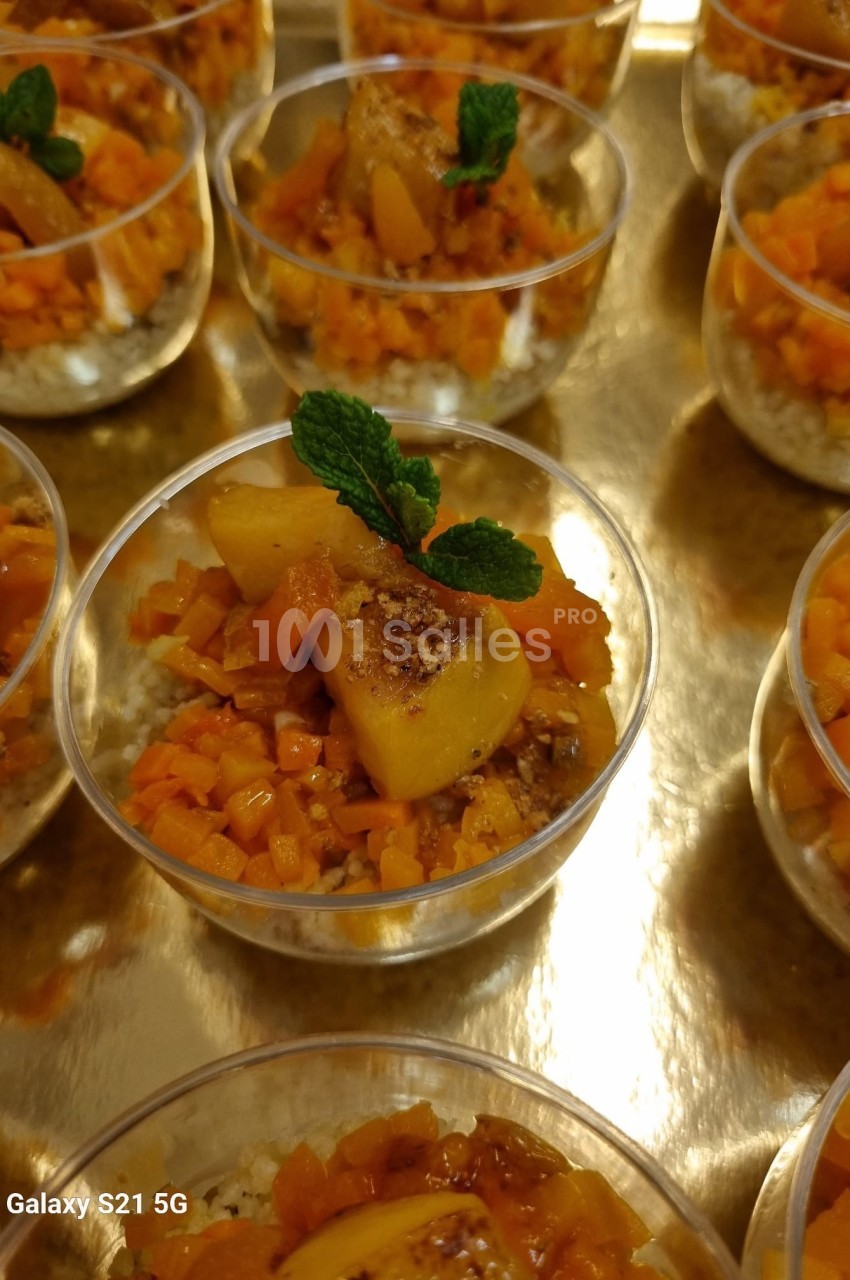 Coupes individuelles de dessert à base de fruits caramélisés, décorées de feuilles de menthe, présentées sur un plateau doré.