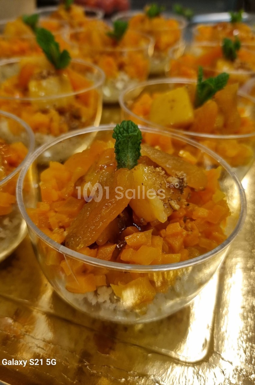 Coupes individuelles de dessert avec fruits coupés en dés, garnies de menthe, présentées sur un plateau doré.