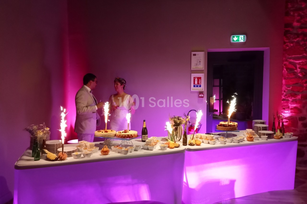 Un couple discute près d'une table de buffet illuminée, décorée de plats et de desserts avec des étincelles.