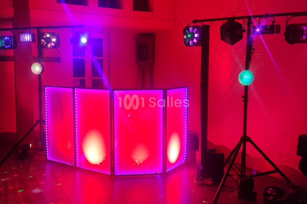 Équipement de lumière et sonorisation installé dans une salle, avec éclairages colorés et ambiance festive.