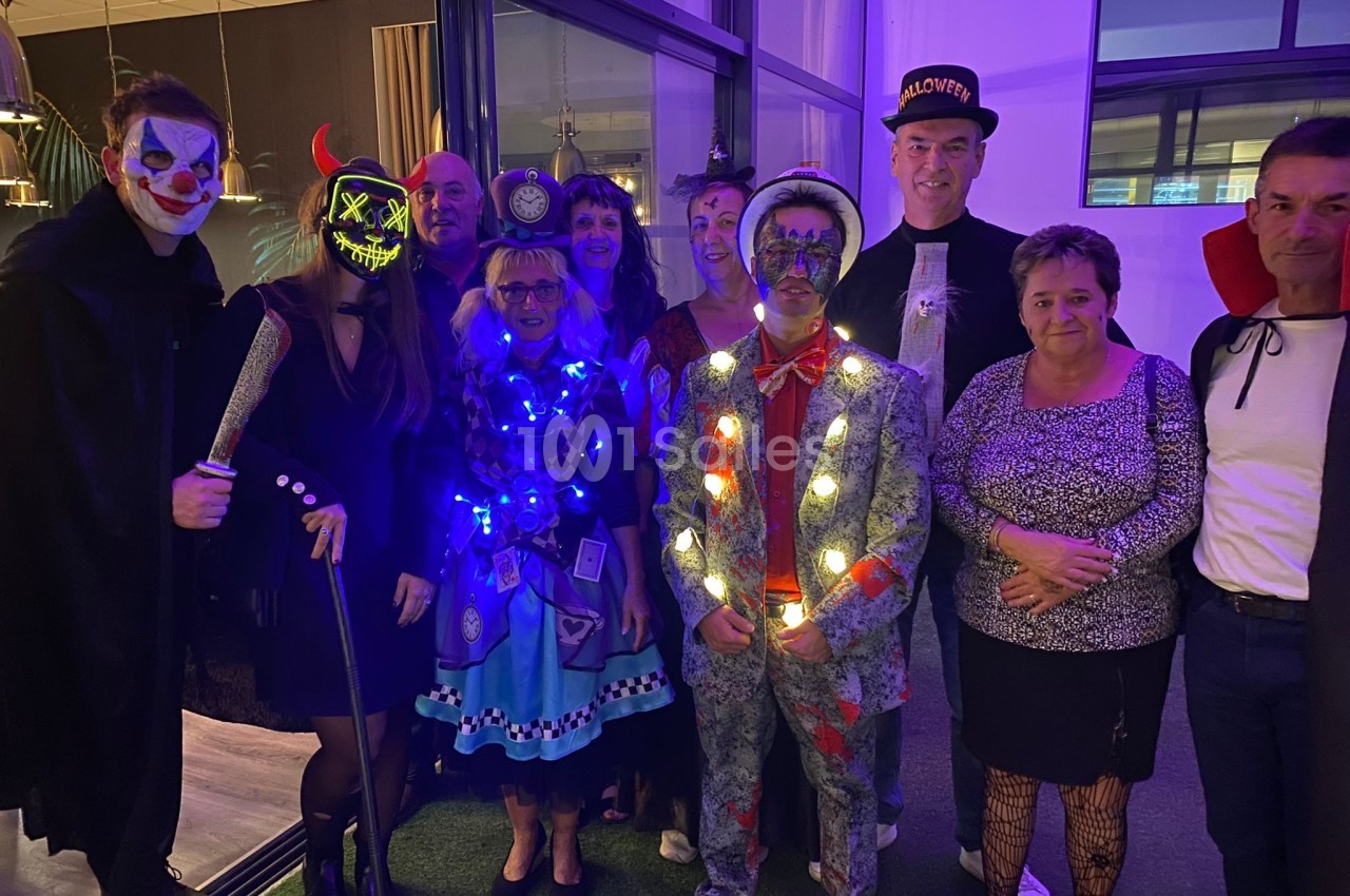 Un groupe de personnes déguisées lors d'une fête, avec des costumes lumineux et des accessoires variés.