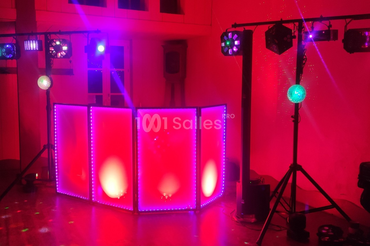 Équipement de lumière et sonorisation installé dans une salle, avec éclairages colorés et ambiance festive.