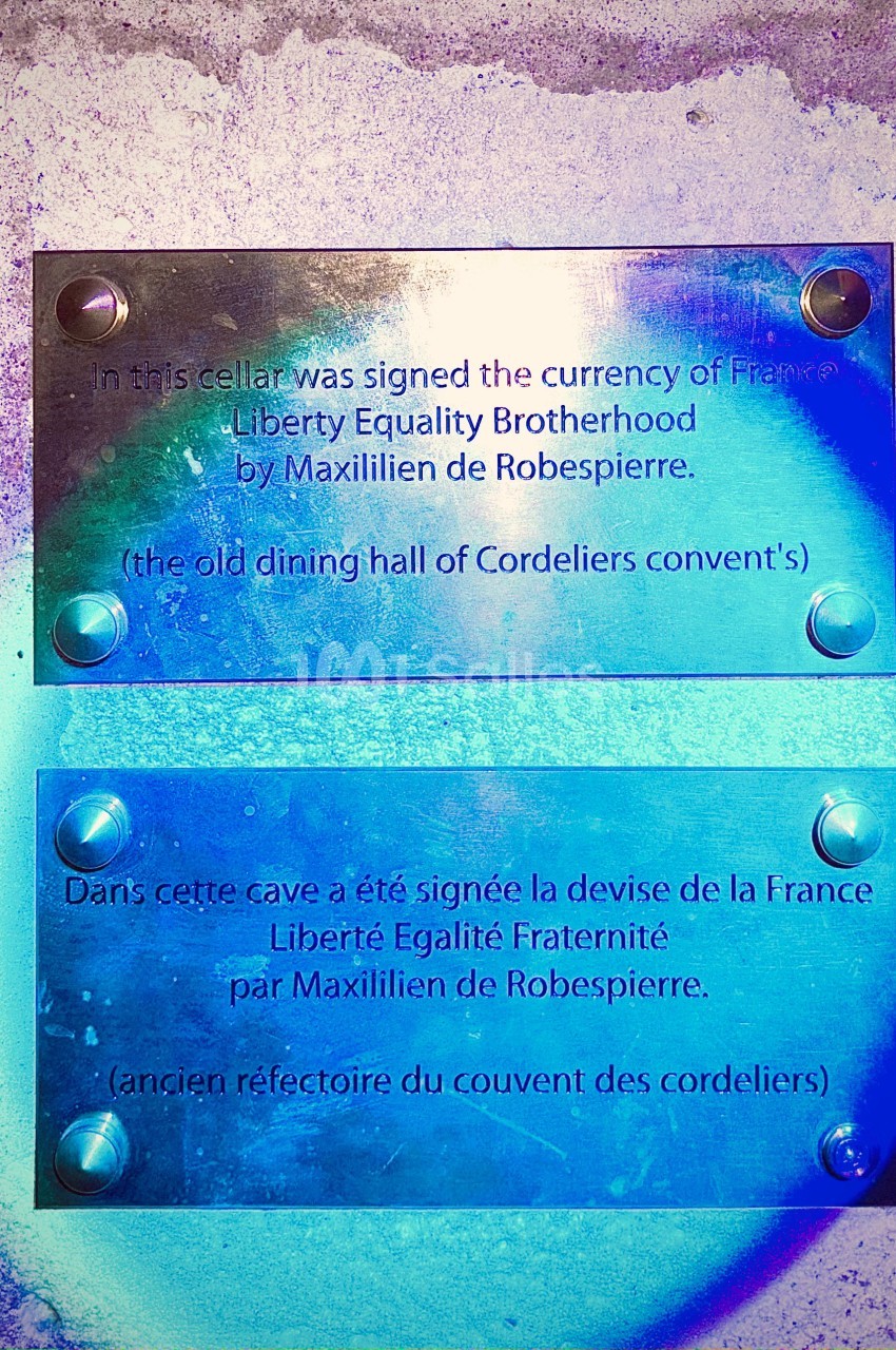 Plaques commémoratives en anglais et français sur un mur, mentionnant la devise de la France signée par Robespierre.