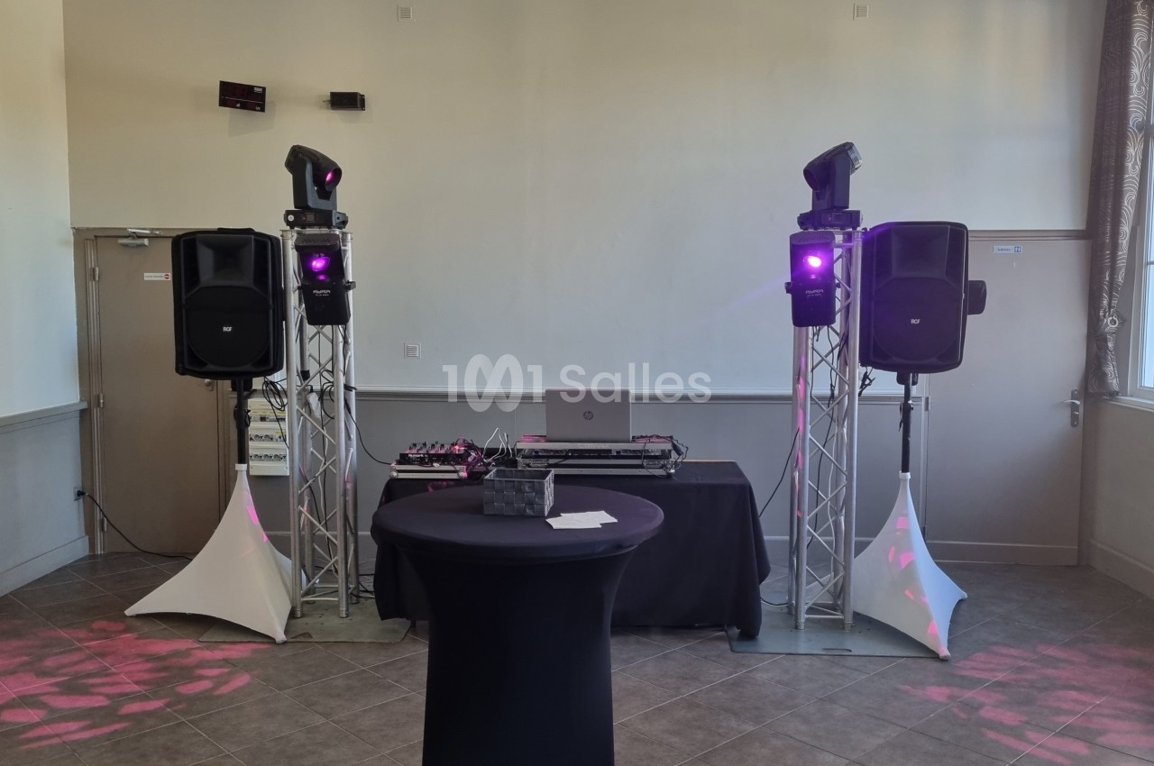 Équipement de sonorisation et éclairage avec table de mixage installé dans une salle lumineuse.